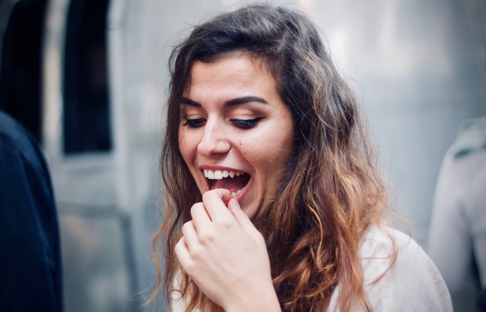 woman holding her tooth with a filling falling out