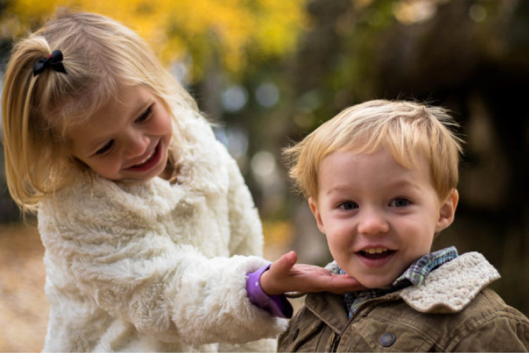 young girl showing off her baby brothers smile