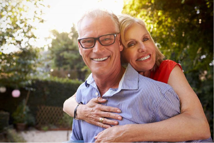 older couple hugging and smiling after Partial Dentures