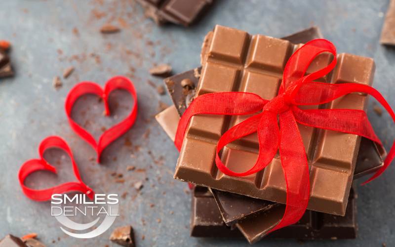 Valentines day treats, chocolate bars, red ribbon hearts