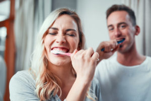 Couple brushing their teeth to remove dental plaque